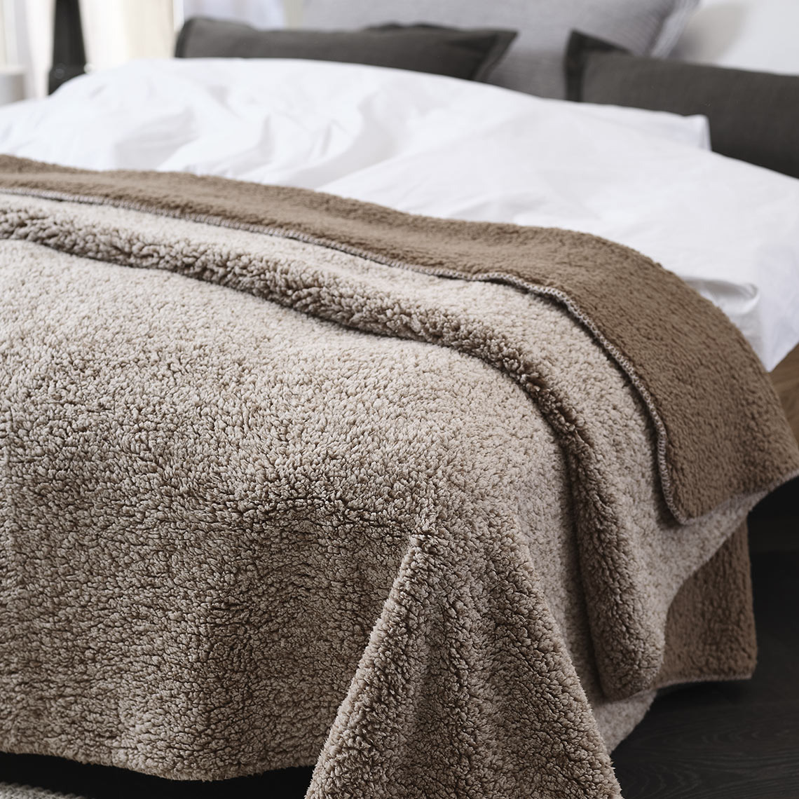 STORFRYTLE Fleece-Decke Braune Fleece-Decke auf einem Bett in einem Schlafzimmer