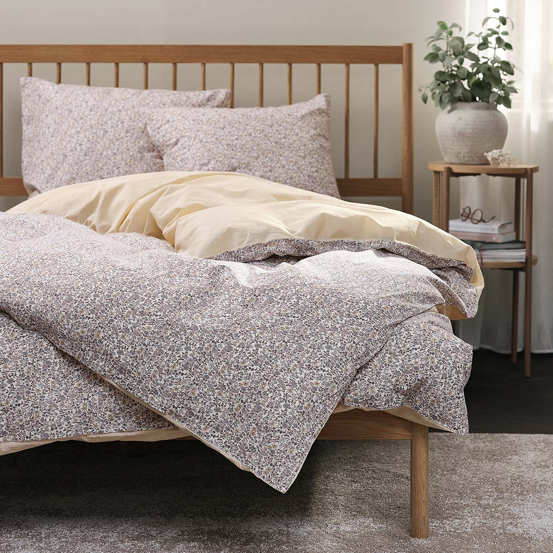 Parure de lit avec motif floral dans des tons clairs de violet et de jaune