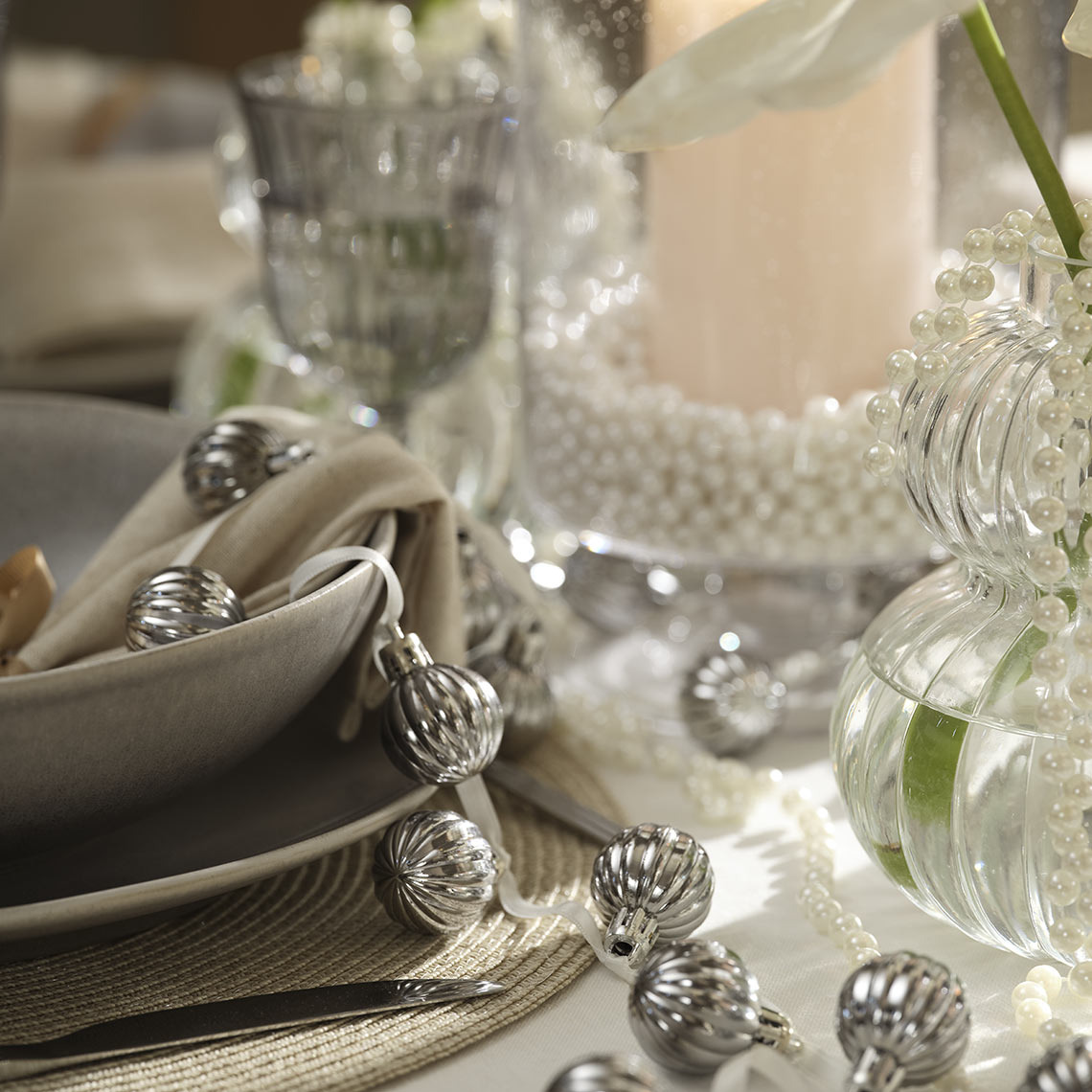 Boules de Noël suspendues à une ficelle sur une table à manger