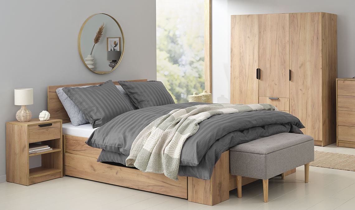 Chambre avec lit double, armoire, table de chevet et banc