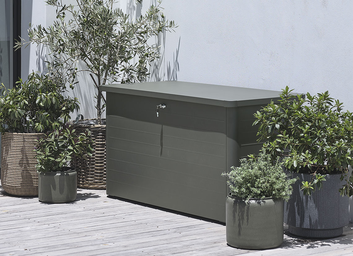 Contenitore portaoggetti grigio da giardino su una terrazza con piante e vasi