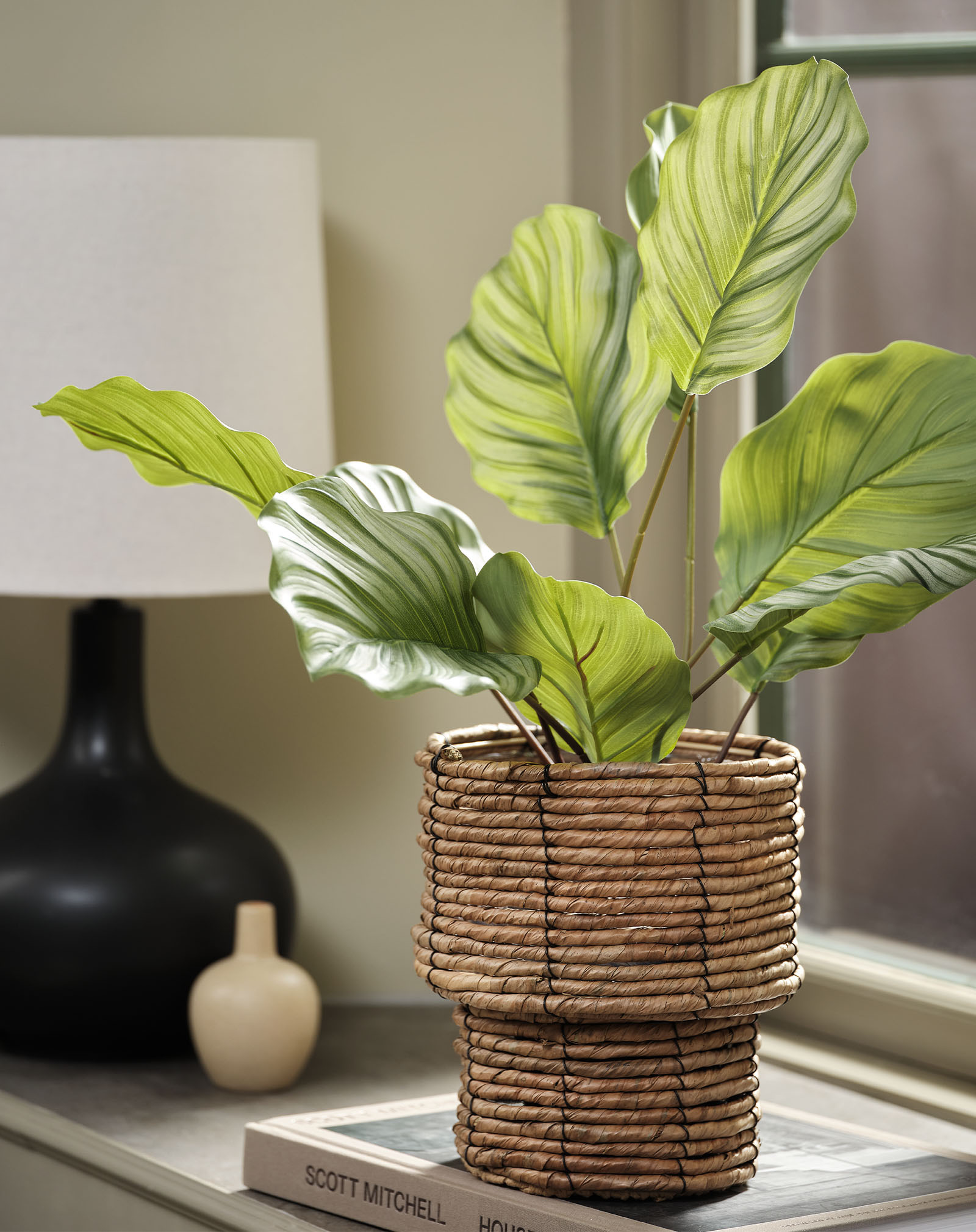 Künstliche Nachbildung einer Calathea in einem geflochtenen Pflanzentopf