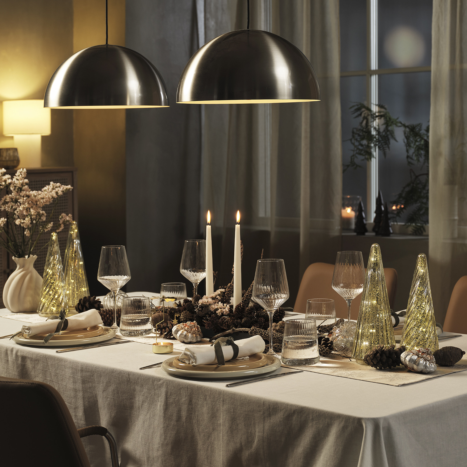 Des vases remplis de fleurs et des décorations de Noël sur une table dressée pour Noël