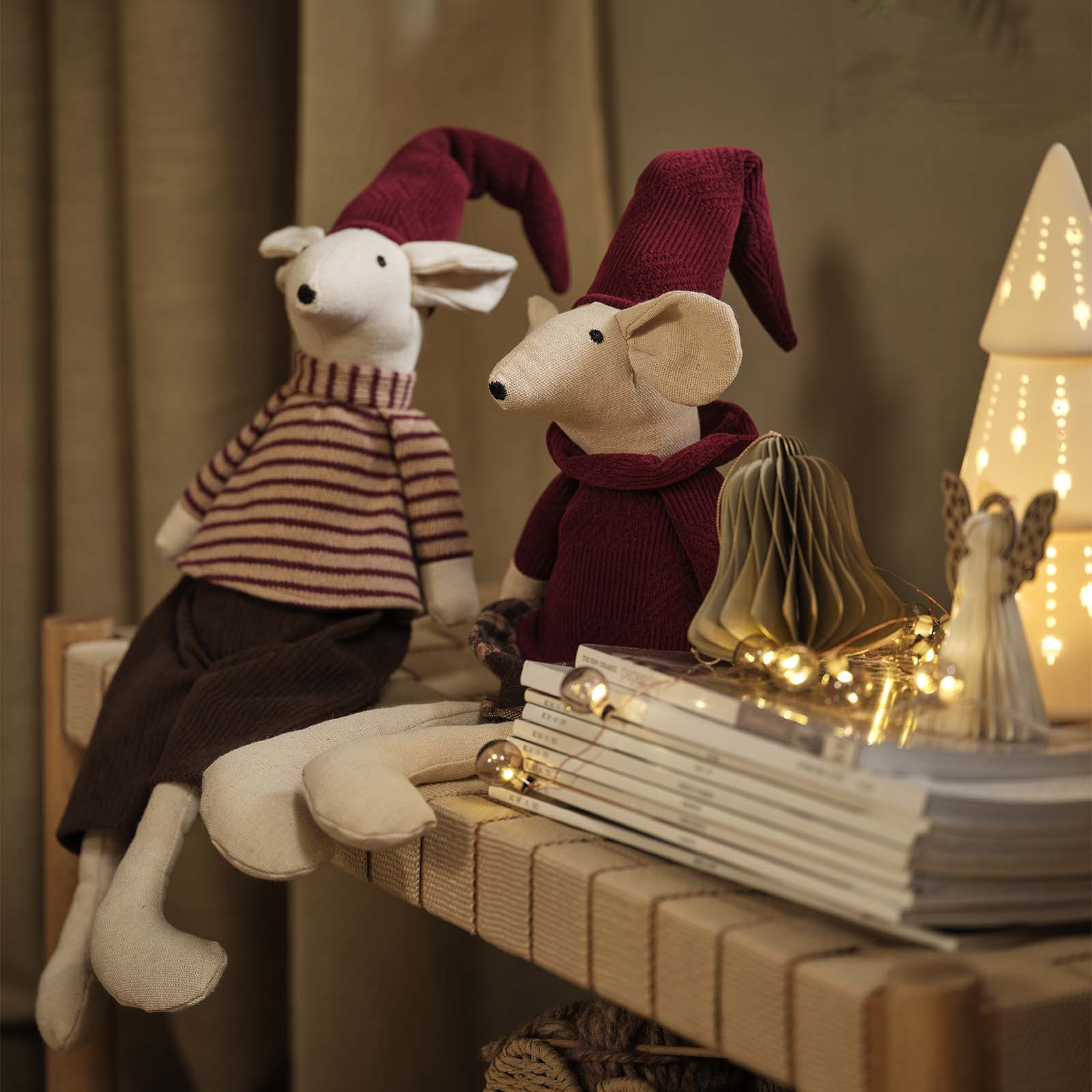Souris de Noël décoratives avec des chapeaux de Noël pointus bordeaux sur une étagère