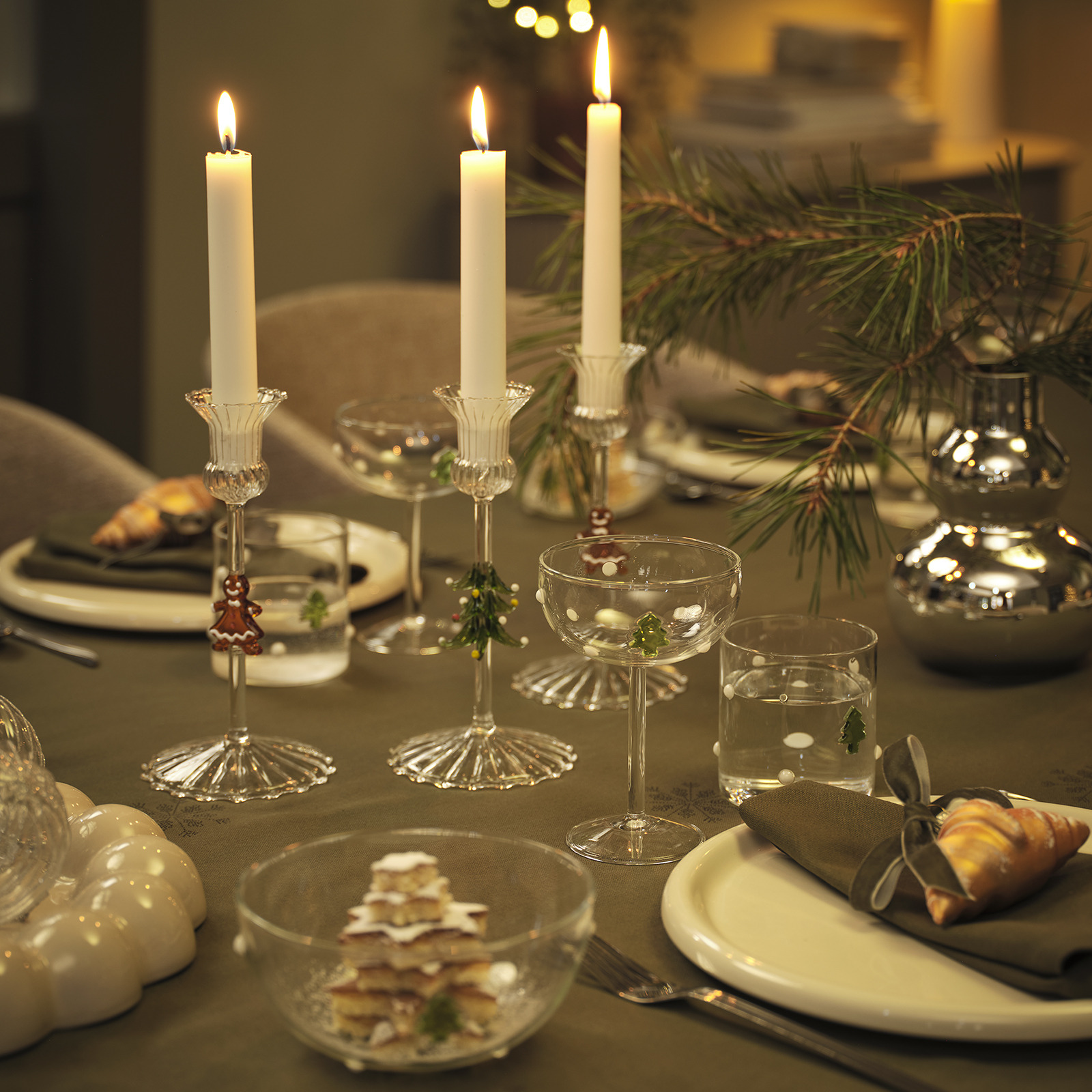 Tavolo da pranzo illuminato a festa da candele, candeline in portacandele e catene di luci