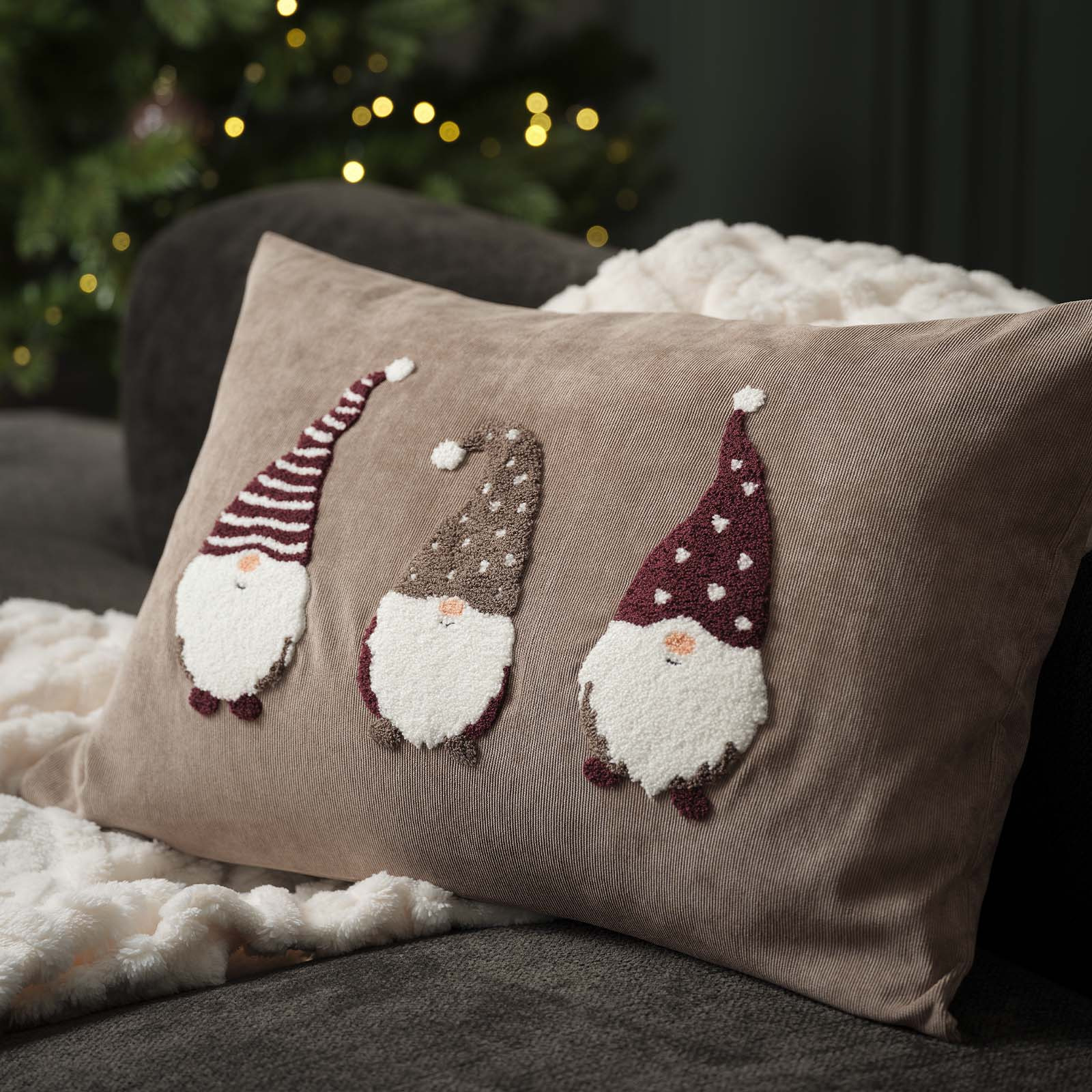 Housse de coussin coloris sable brodée de lutins de Noël avec des bonnets de Noël et de grosses barbes