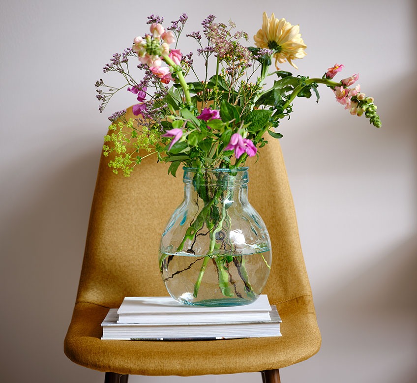 Blumenvase aus Glas auf einem Esszimmerstuhl 