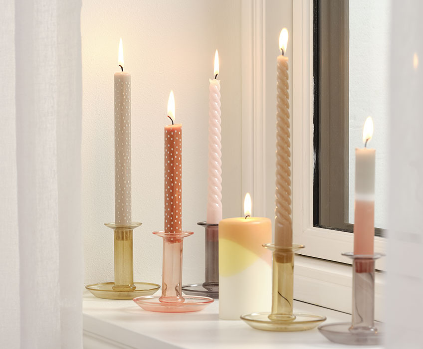 JULIAN dotted candles, VEGAR pillar candle, twisted BALDUR candles and INGI taper candle in EDGAR glass candlesticks Candles in candlesticks in a windowsill