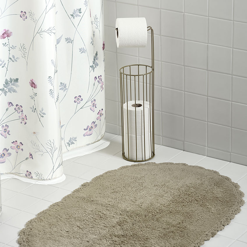 Rideau de douche, tapis de bain et porte-rouleau WC dans une salle de bain